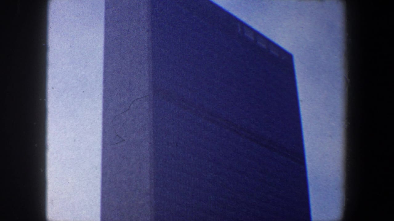 Low-angle view of the United Nations Headquarters tower against a pale sky.