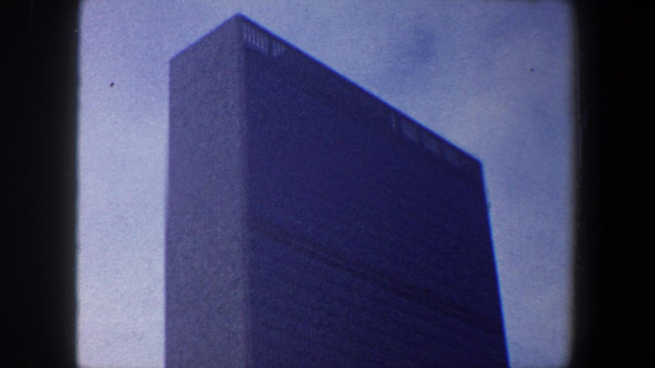 Low-angle tower facade with pale sky and visible film gate edges.
