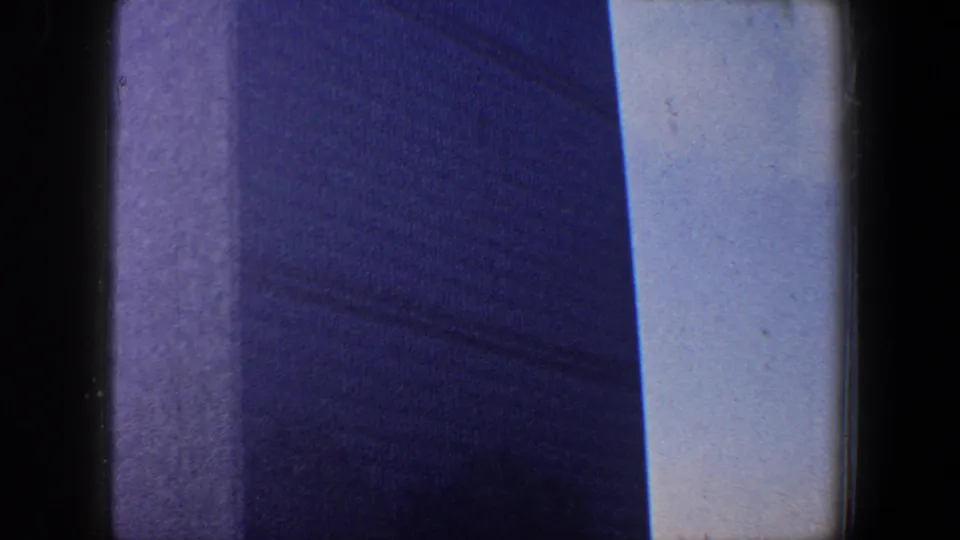 1960 New York City home-movie frame showing the United Nations Headquarters tower rising through a handheld low-angle composition.