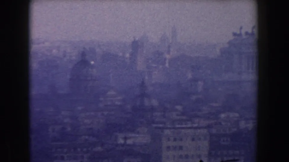 A hazy 1959 Rome city view shows domes, rooflines, and classical silhouettes under muted daylight.
