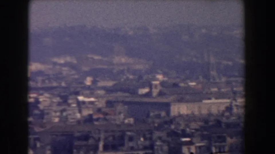 Rome skyline in 1959 home-movie footage, with layered rooftops and towers visible through atmospheric haze.