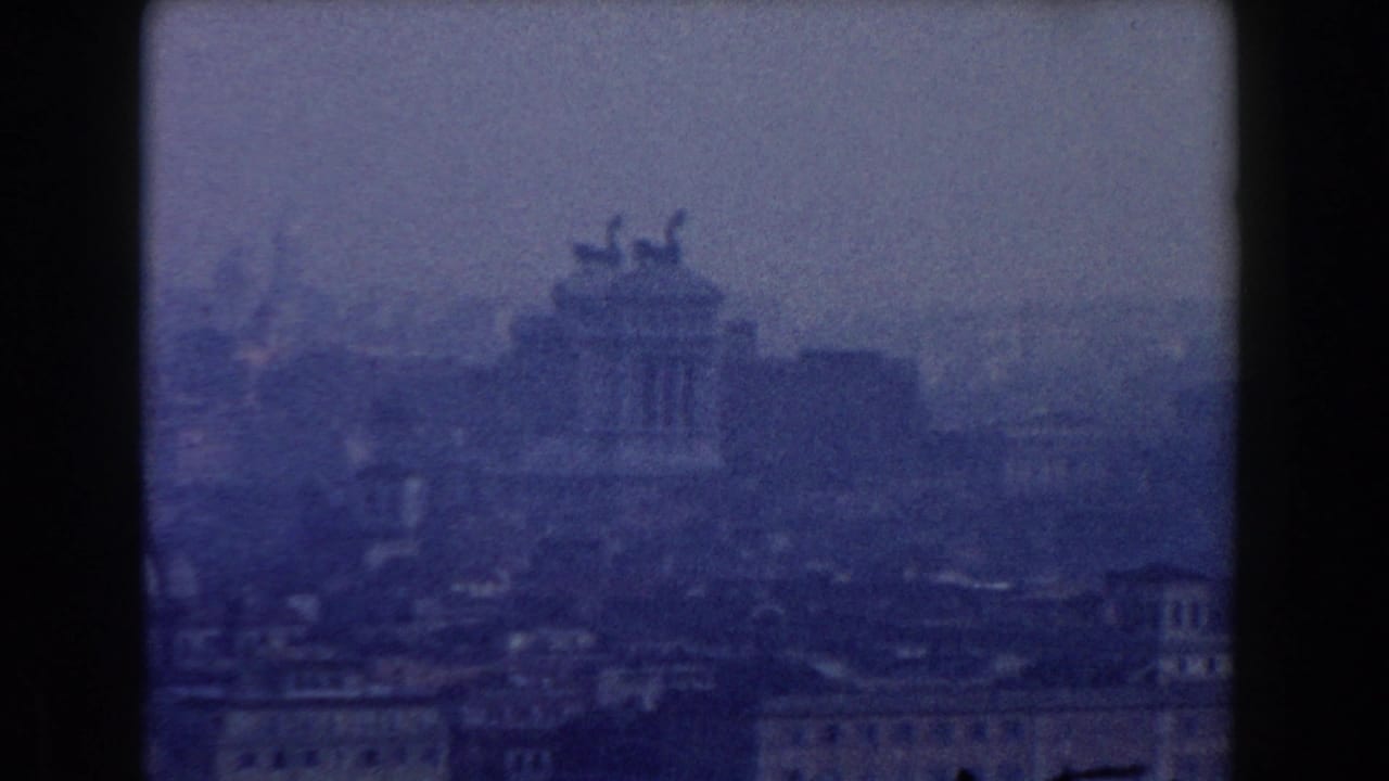 Hazy distant view of the Altare della Patria above Rome rooftops.