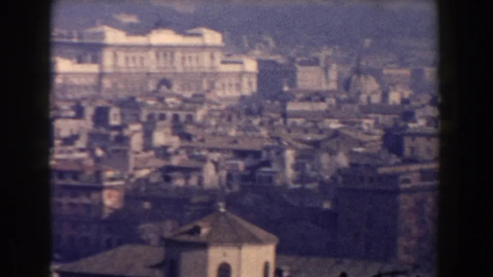1959 Rome panorama showing dense rooftops, a prominent white civic building, domes, and hills beyond the city.