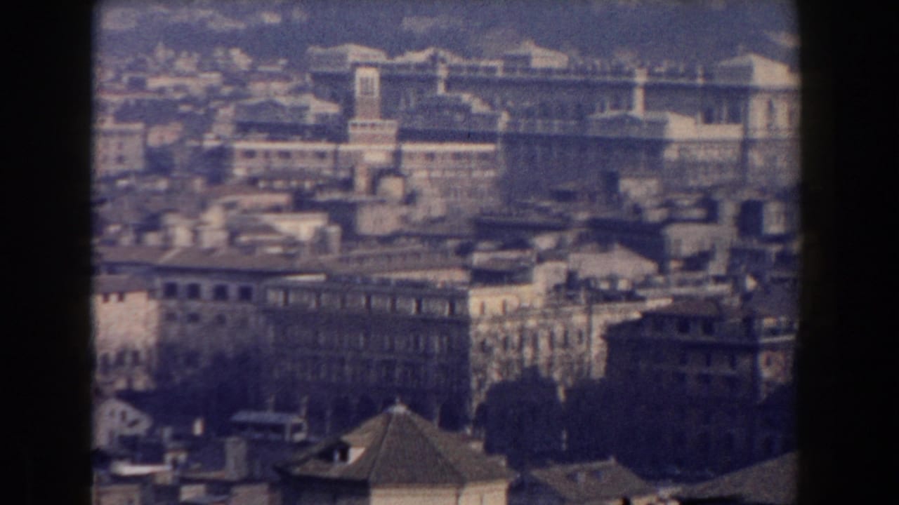 Elevated view over a dense city with large historic buildings in the distance.