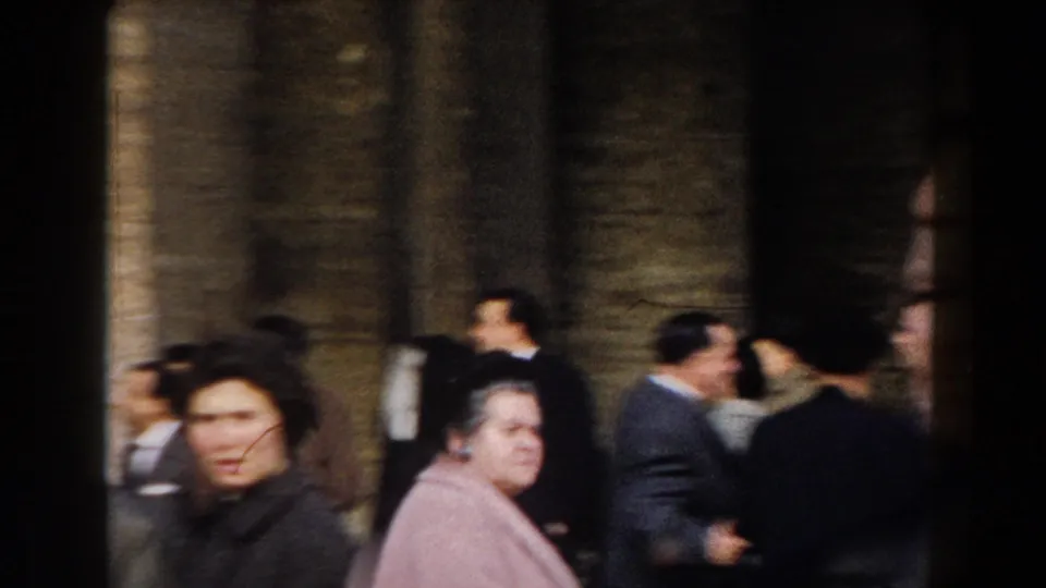 1959 Rome exterior frame with adults outside a grand stone church, some turning toward the handheld camera.