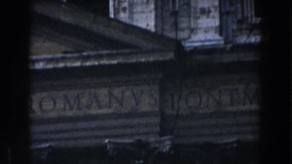 1959 Rome frame showing a classical stone facade with a partial Latin-style inscription, roof edge, and carved architectural detail.