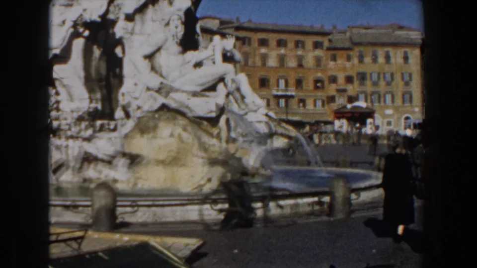 1959 Rome footage shows the Trevi Fountain, surrounding buildings, and a motion-blurred pedestrian passing near the water basin.