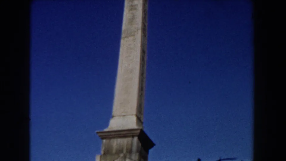 1959 Rome 8mm frame focused on the weathered vertical column, with its base and top cropped by the home-movie framing.