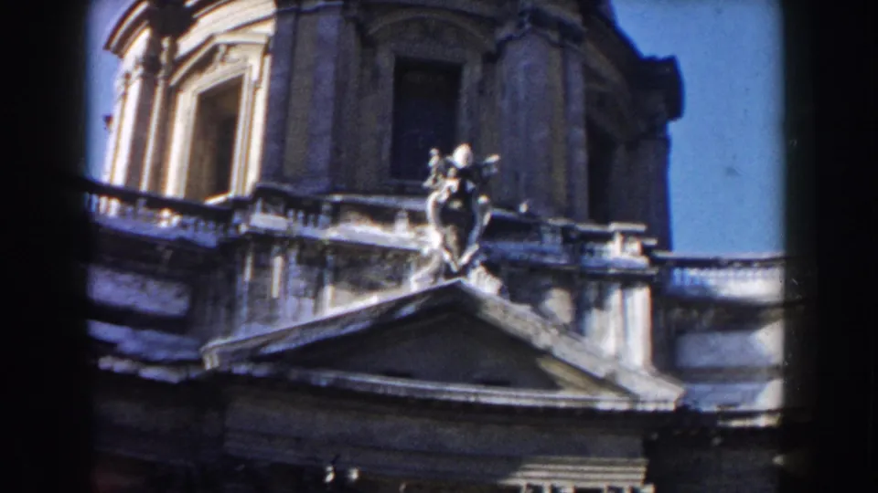 1959 Rome frame of a domed stone building with a sculpted figure above a triangular pediment against blue sky.