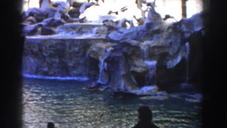 Rome Trevi Fountain in 1959, showing water falling over stonework with silhouetted visitors at the lower edge.