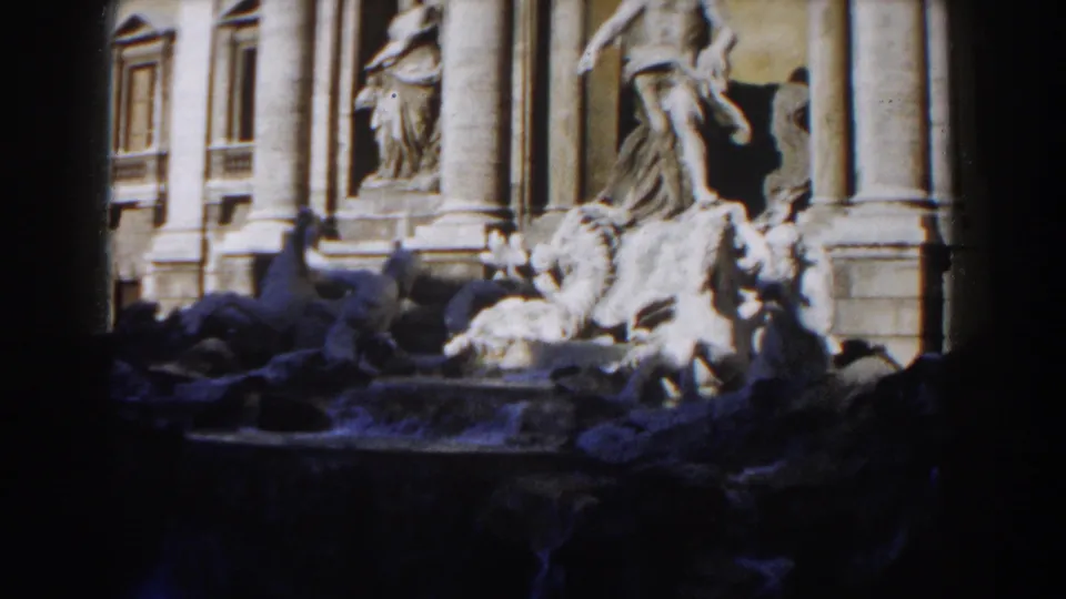 1959 8mm view of the Trevi Fountain in Rome, with marble figures and columns partly obscured by dark foreground shadow.