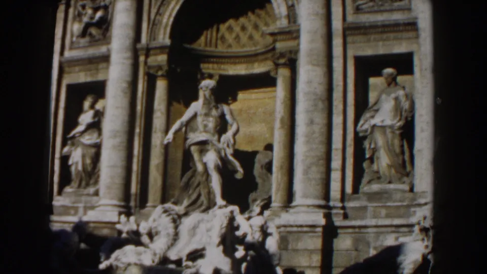 1959 Rome 8mm frame of the Trevi Fountain showing marble statuary, paired columns, arched niches, and fountain rocks.