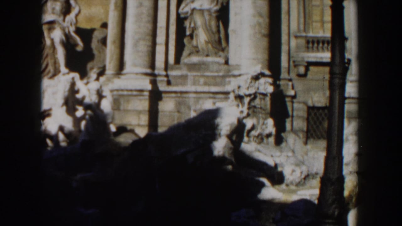 Trevi Fountain sculptures partly framed by dark foreground shadows.