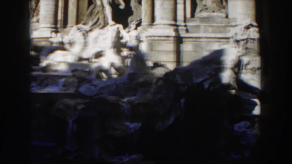 1959 Rome 8mm view of Trevi Fountain figures, rockwork, and water, bordered by dark vertical foreground shapes.