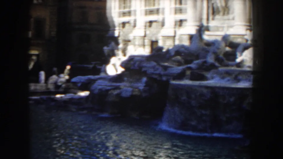 1959 Rome 8mm frame with a wider view of Trevi Fountain rockwork, water, and the surrounding architectural facade.