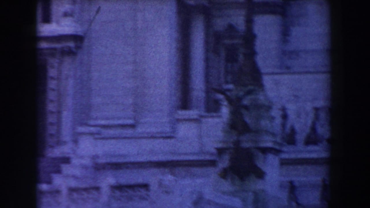 Soft blue-toned view of an ornate stone facade with windows and carved details.