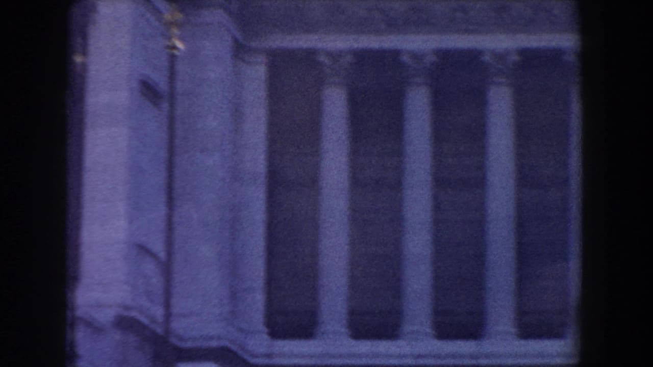 Close view of a columned building corner with stone trim.