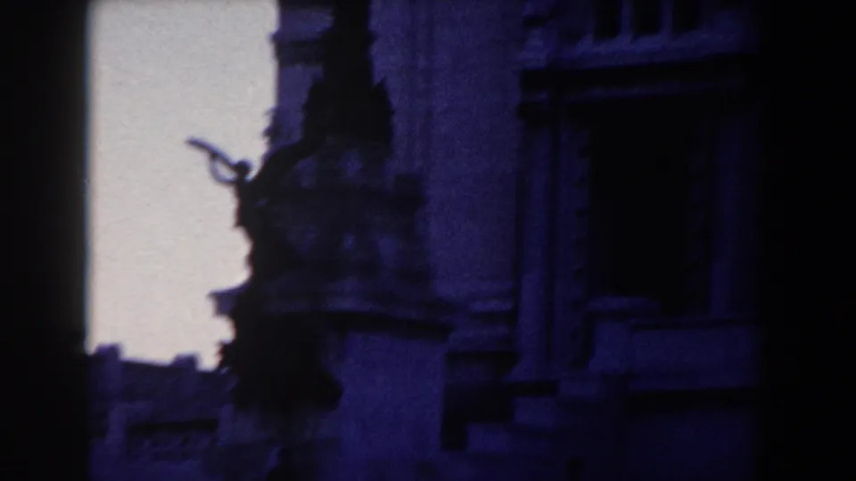 1959 Rome 8mm view of a shadowed sculptural figure near a classical facade with windows and heavy architectural trim.