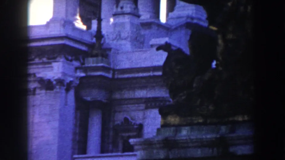 1959 Rome 8mm frame of a classical building facade with columns, carved ledges and a dark foreground statue form.