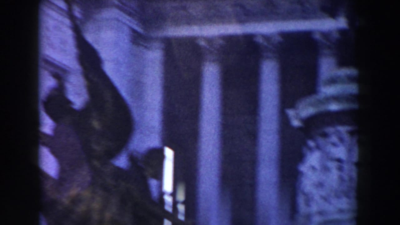 1959 Rome 8mm frame showing monument columns and sculptural stone detail through soft, purple-tinted exposure.
