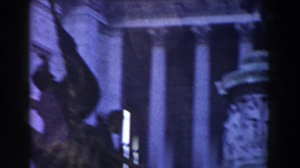 1959 Rome 8mm frame showing monument columns and sculptural stone detail through soft, purple-tinted exposure.