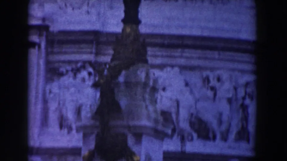 1959 Rome frame showing carved relief panels, a lamp post, and ornate stone architecture on a civic monument.