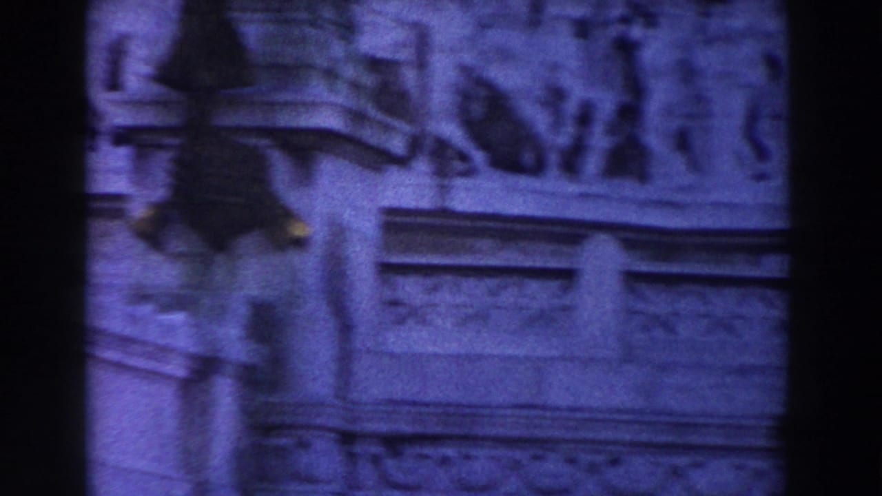 Close view of carved stone frieze and architectural detail with dark film edges.