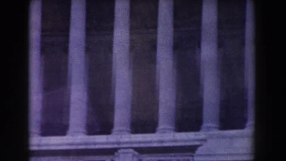 1959 Rome visitor footage showing a shadowed colonnade with tall stone columns and soft 8mm focus.