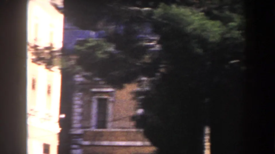 1959 Rome frame showing a warm-toned facade with windows, trees, and a dark foreground divider.