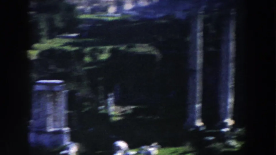 1959 Rome 8mm view of garden greenery, weathered stonework, and tall classical columns in a blurred handheld pan.