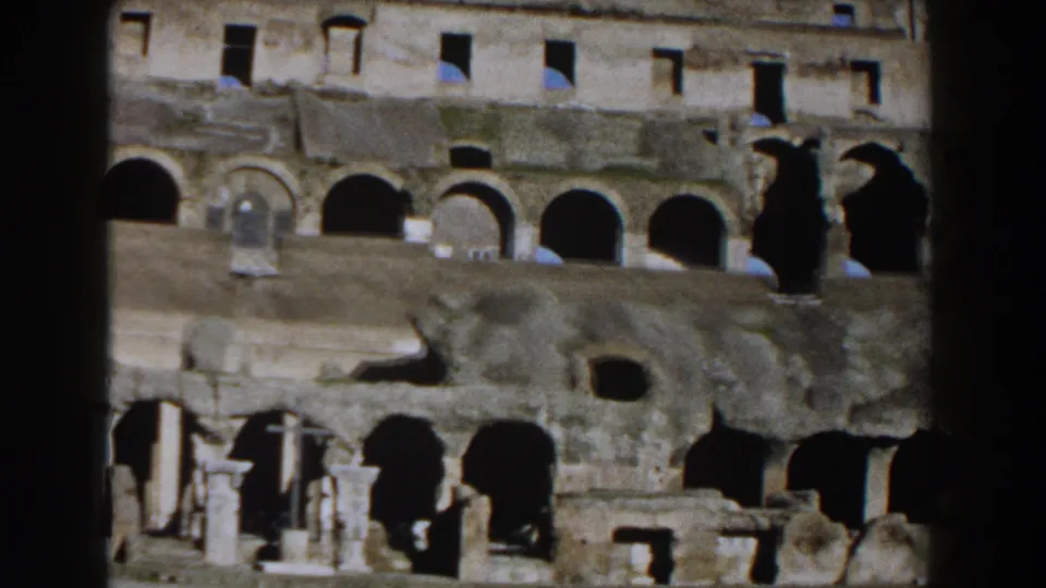 1959 Rome footage of the Colosseum interior with layered stone tiers, arched passages, small openings, and strong shadow contrast.