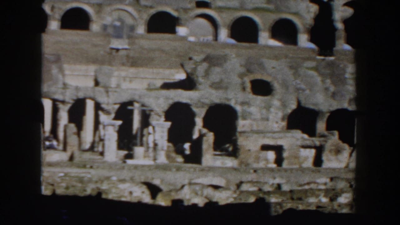 Weathered Colosseum arches seen through dark interior framing.