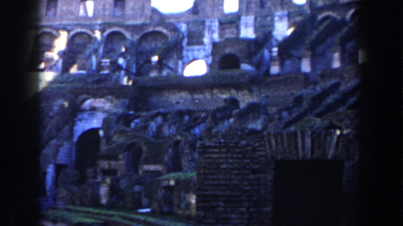 Interior Colosseum stone arches and shadowed ruins under daylight.