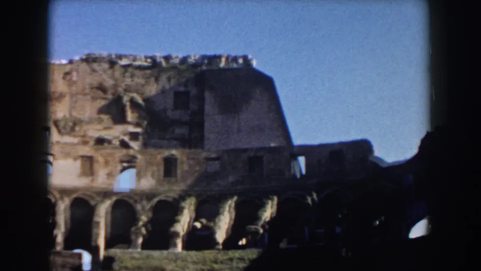 Rome Colosseum interior in 1959, showing a weathered wall section, arched lower level, and clear daylight sky.