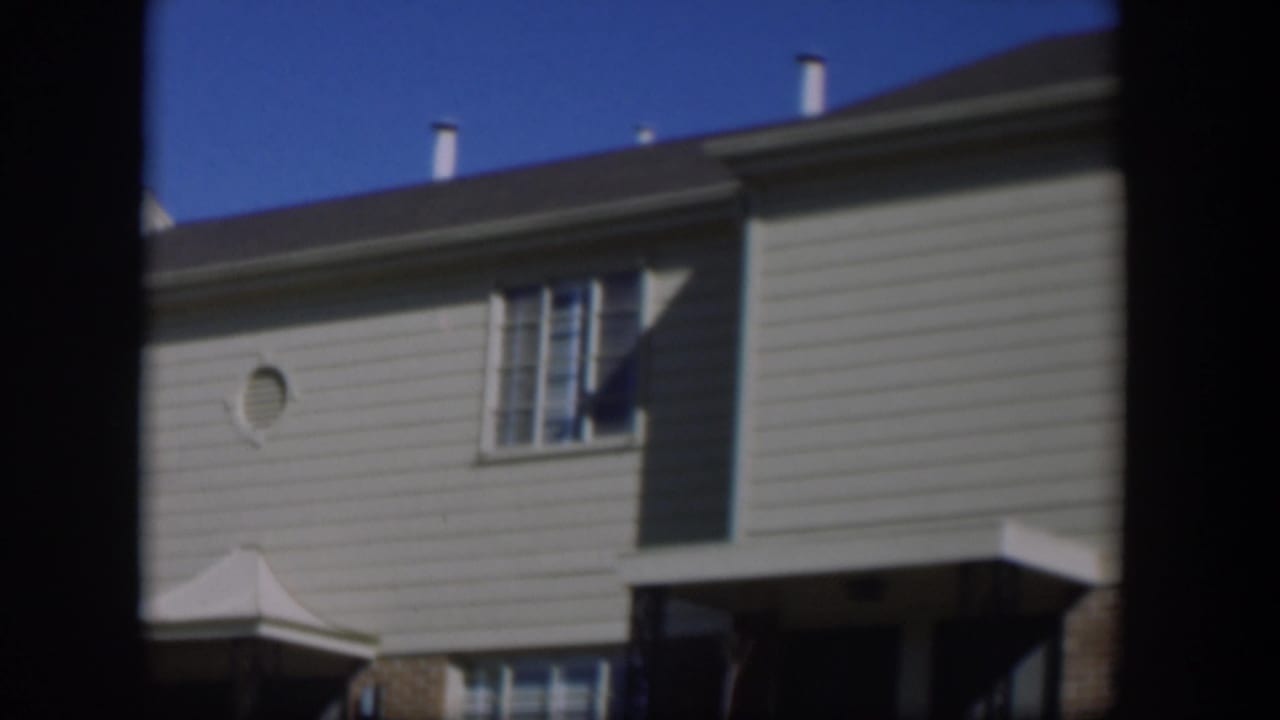 House facade with circular vent, windows, and covered entry.