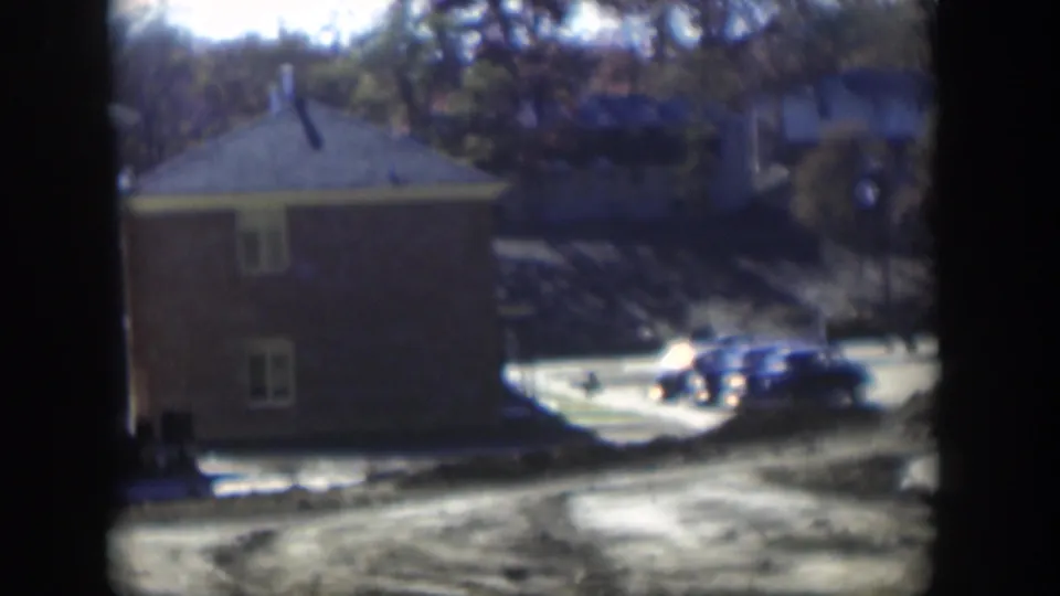End frame shows a blue sedan beside an apartment building in daylight, with trees and road surfaces visible through 8mm gate edges.