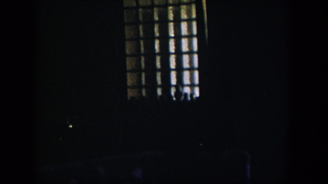 Very dark room detail with a bright gridded window at the upper right.