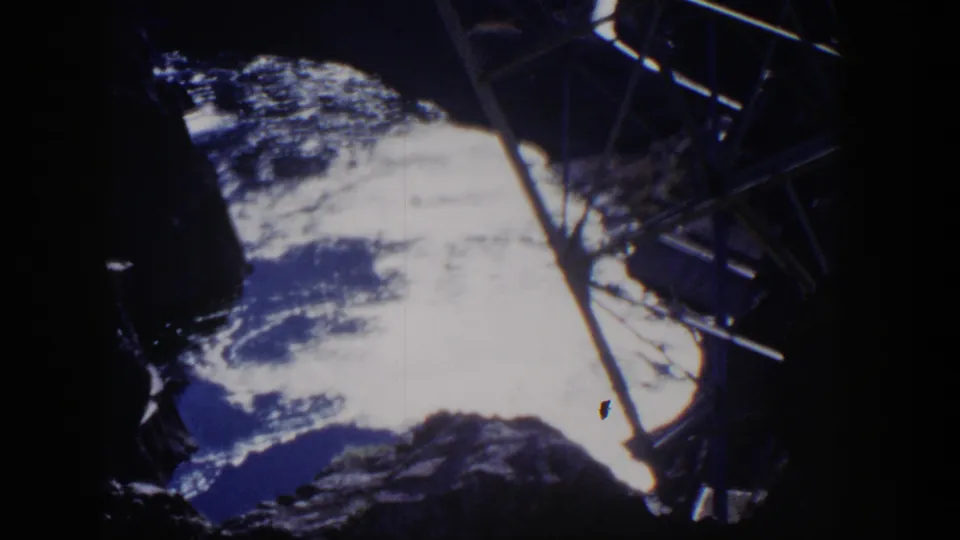 1954 Nevada 8mm frame showing water between rocky walls and a dark metal structure along the right edge.