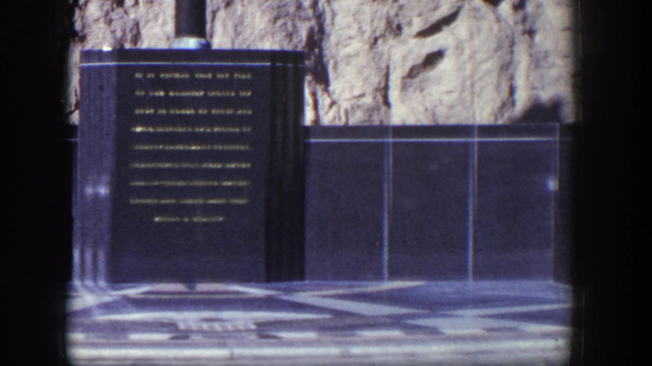Centered inscribed stone panel with gold text, tiled wall, and patterned floor.