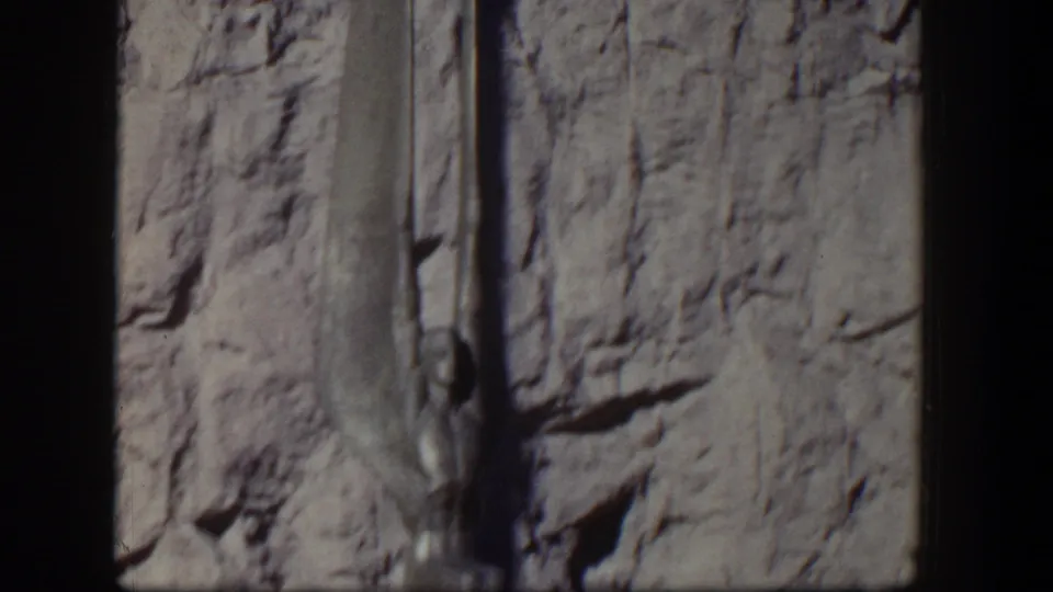 1954 Nevada 8mm frame with a similar view of the Egyptian-style wall sculpture and surrounding stone surface.