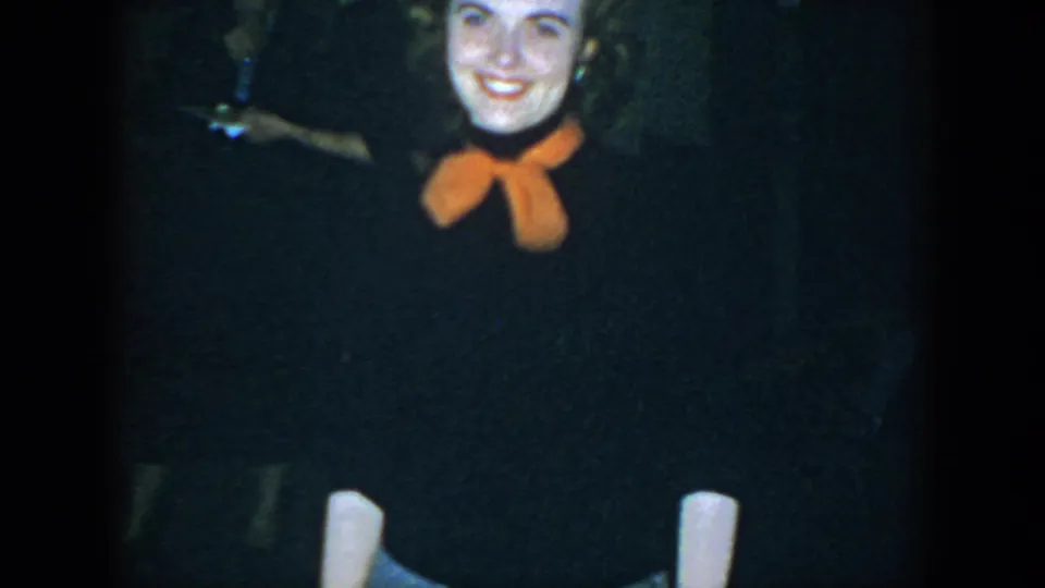 The final frame crops the woman's face and torso as she smiles in the dim 1952 Houston gathering, with other guests still visible behind her.
