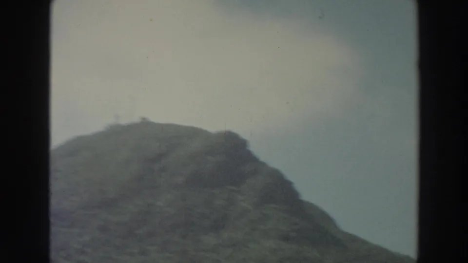 1966 Puerto Rico 8mm frame showing a wooded hillside under a pale sky, with soft focus and visible film borders.