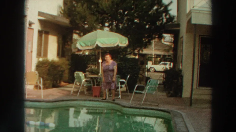 A woman in a purple dress stands poolside in Puerto Rico, framed by 1960s patio furniture and warm 8mm color.
