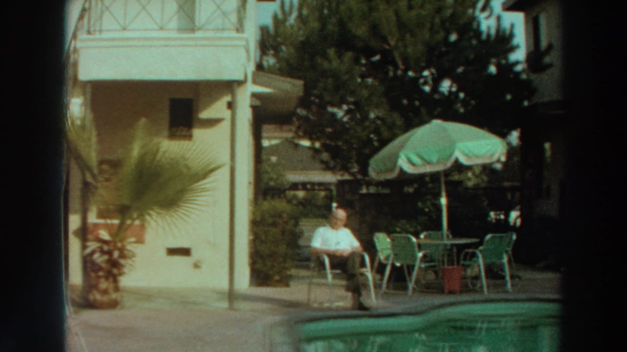 The 1966 Puerto Rico poolside scene shows a seated man, green patio chairs, an umbrella, palm foliage, and a residential building.