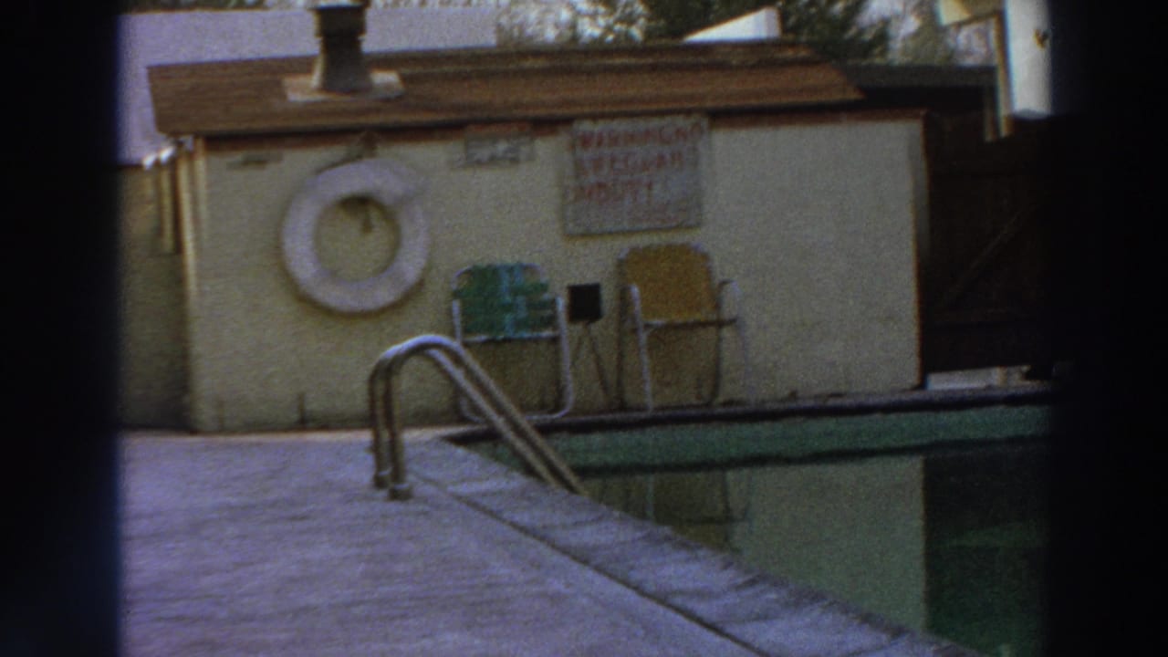 1966 Puerto Rico frame showing a poolside warning sign, white life preserver, metal chairs, ladder, and green pool edge.