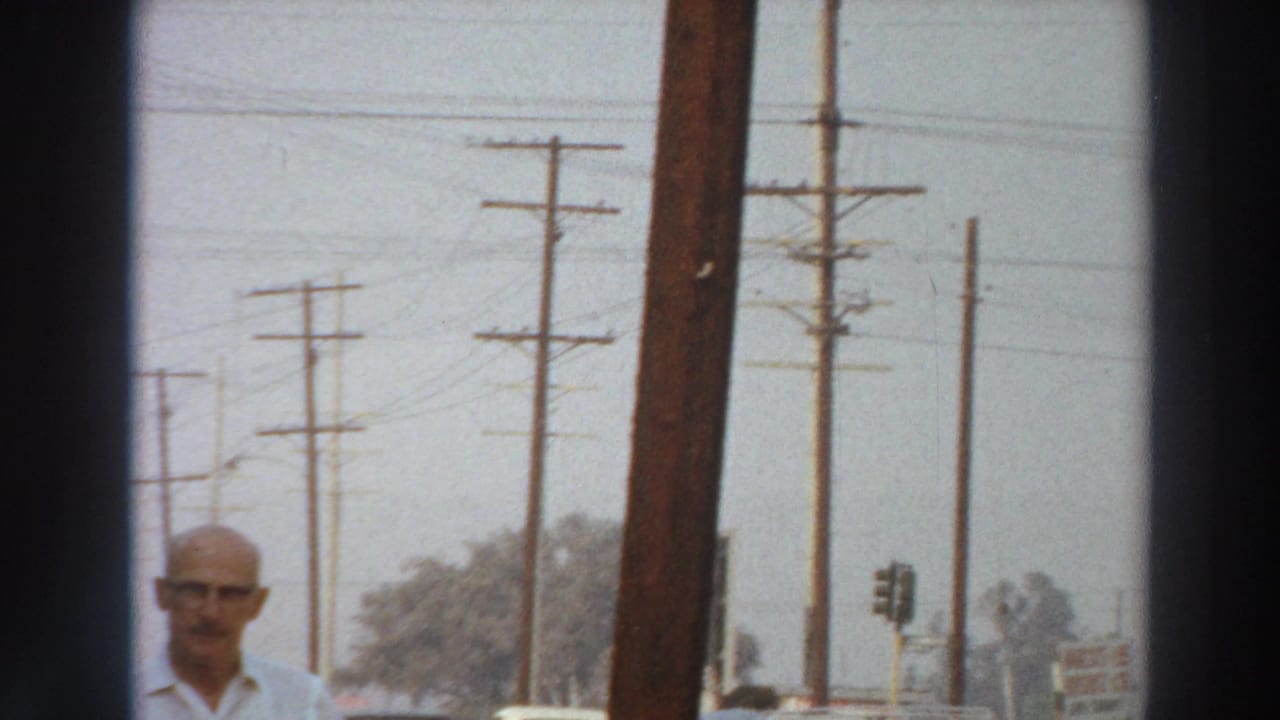 The clip shifts to a Puerto Rico street view with utility poles, overhead wires, distant trees and a man partly visible near the lower edge.
