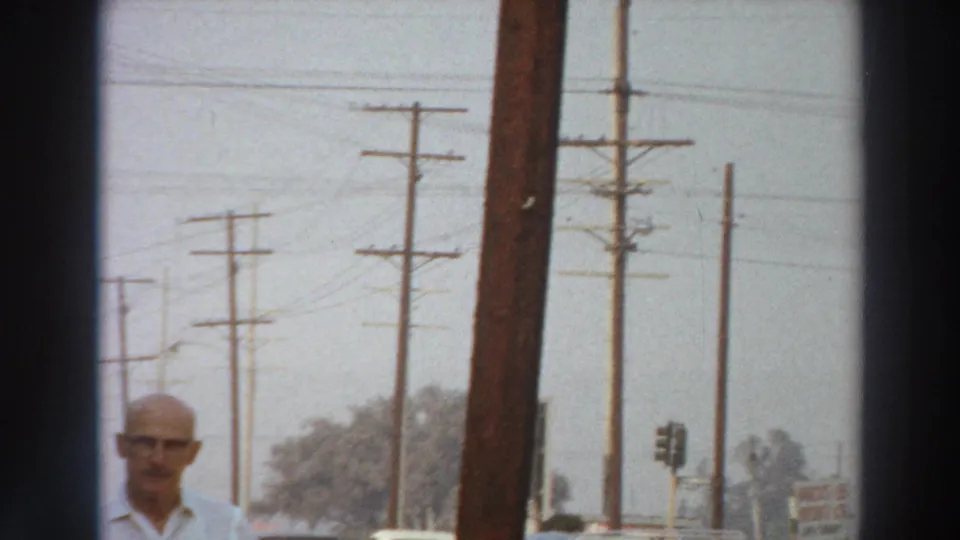 The clip shifts to a Puerto Rico street view with utility poles, overhead wires, distant trees and a man partly visible near the lower edge.