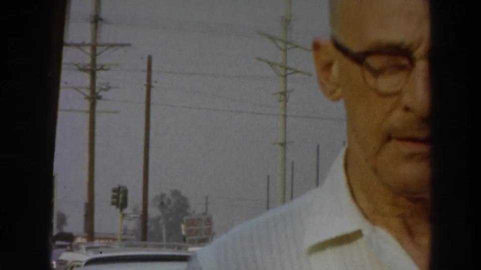 A cropped close view shows the man in glasses at the edge of the frame, with Puerto Rico roadside poles and cars visible behind him in 1966 footage.