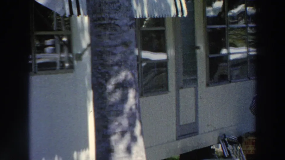 The final frame shows the windowed building, palm trunk, striped awning, and a partial edge view of the man working outside in Puerto Rico.