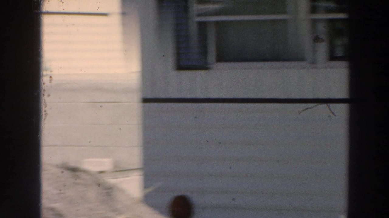 A residential wall and window in Puerto Rico, filmed in 1966 with strong shadow and soft 8mm exposure.